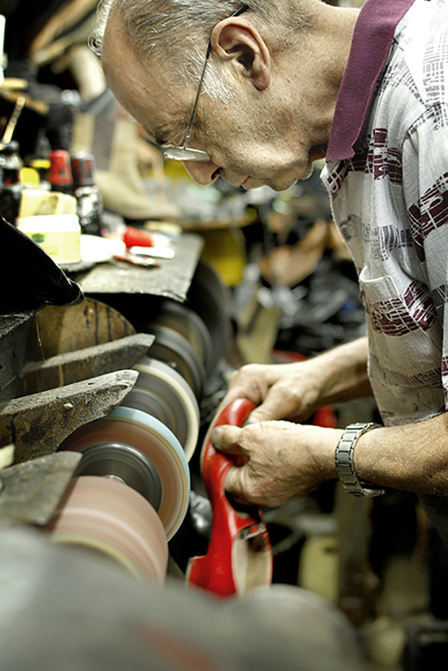 Close-up of Roger grinding a heel on the buffing wheel