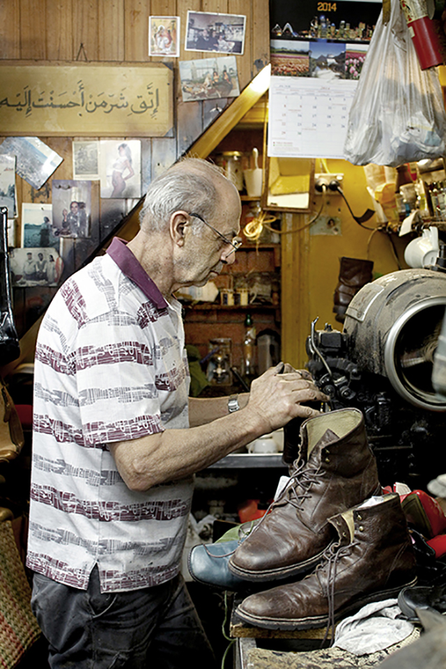 Roger hand-finishing a leather boot at his workbench